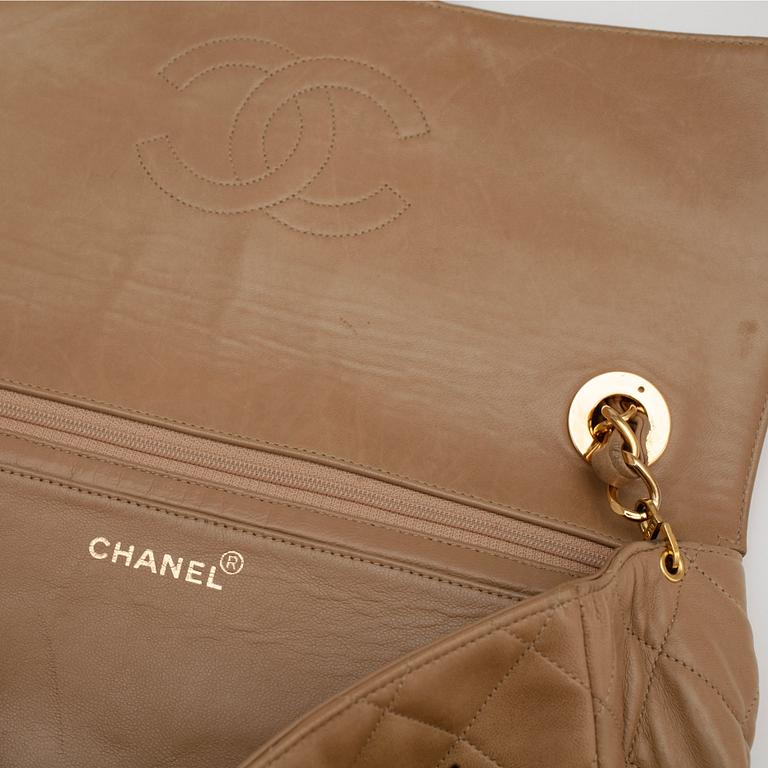CHANEL, a qulited beige leather shoulder bag.