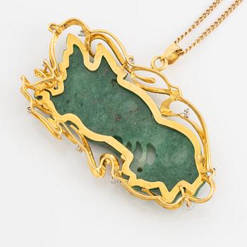 Pendant in gold with a carved green stone, adorned with brilliant-cut diamonds.