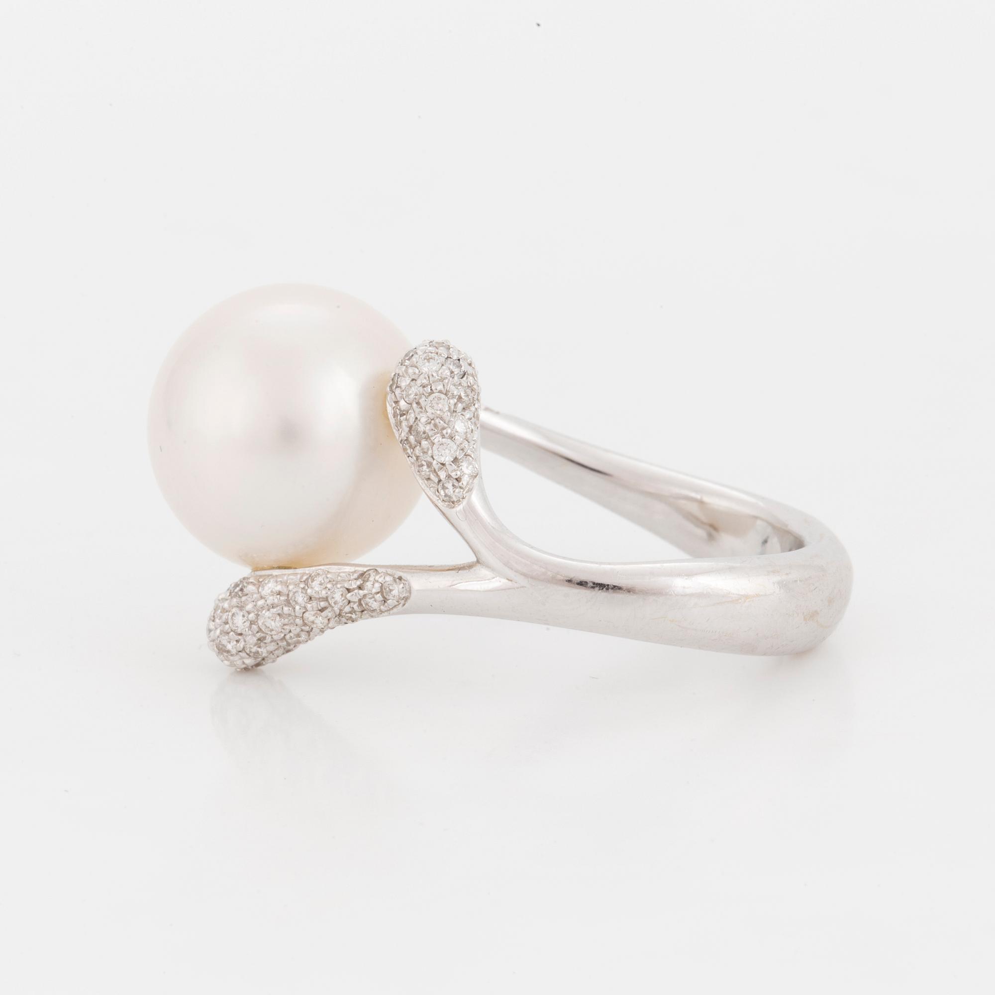 A ring set with a cultured 'South Sea' pearl and round, brilliant-cut diamonds.
