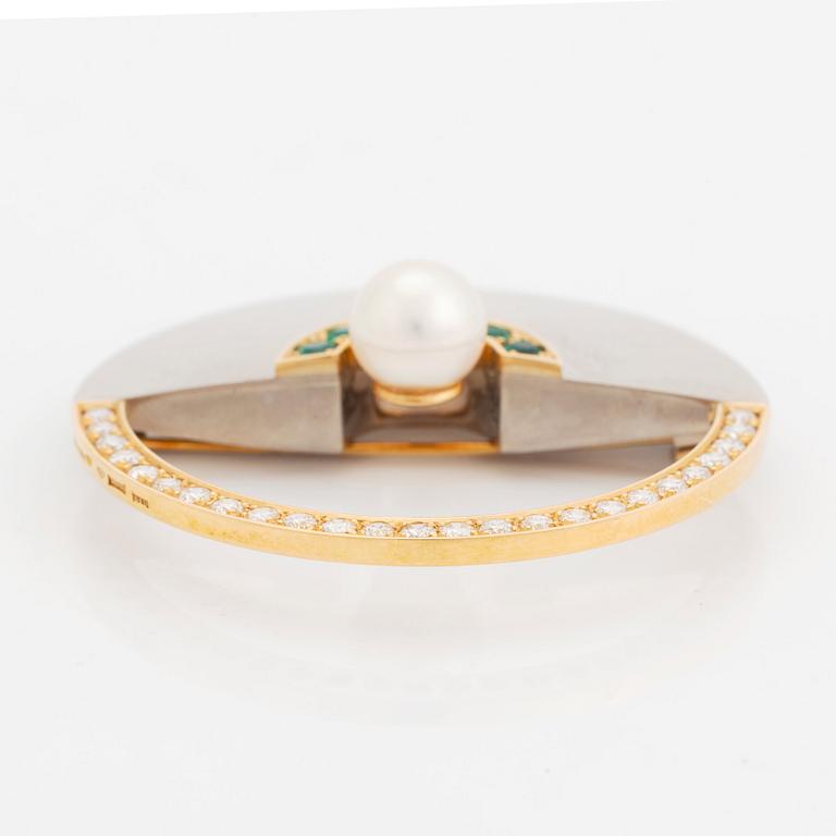 An 18K gold and white gold brooch set with a cultured pearl, round brilliant-cut diamonds and emeralds.