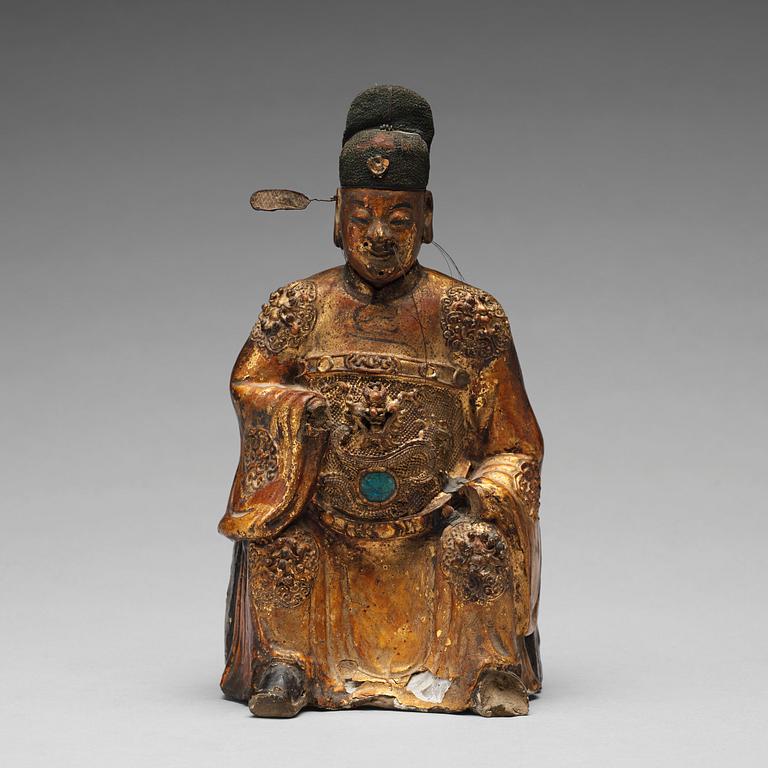 A lacquered and gilt ceramic sculpture of a deity, Ming dynasty (1368-1644).