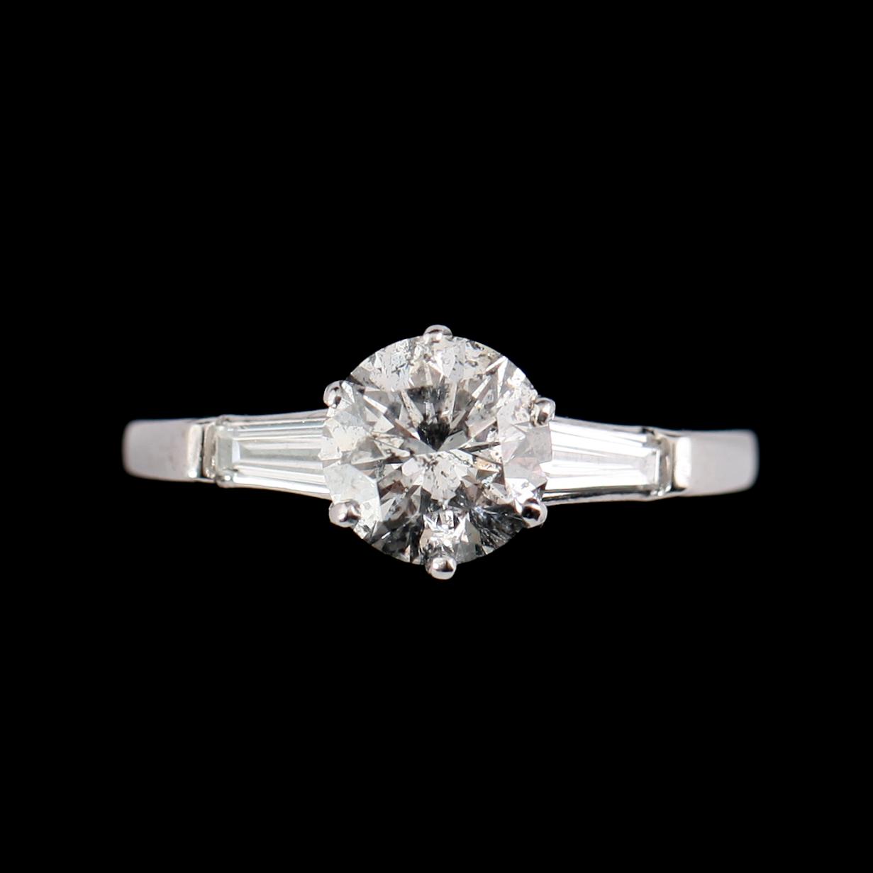 RING, 18 k vitguld, med briljantslipad diamant 1.31 ct och 2 baguetteslipade diamanter.