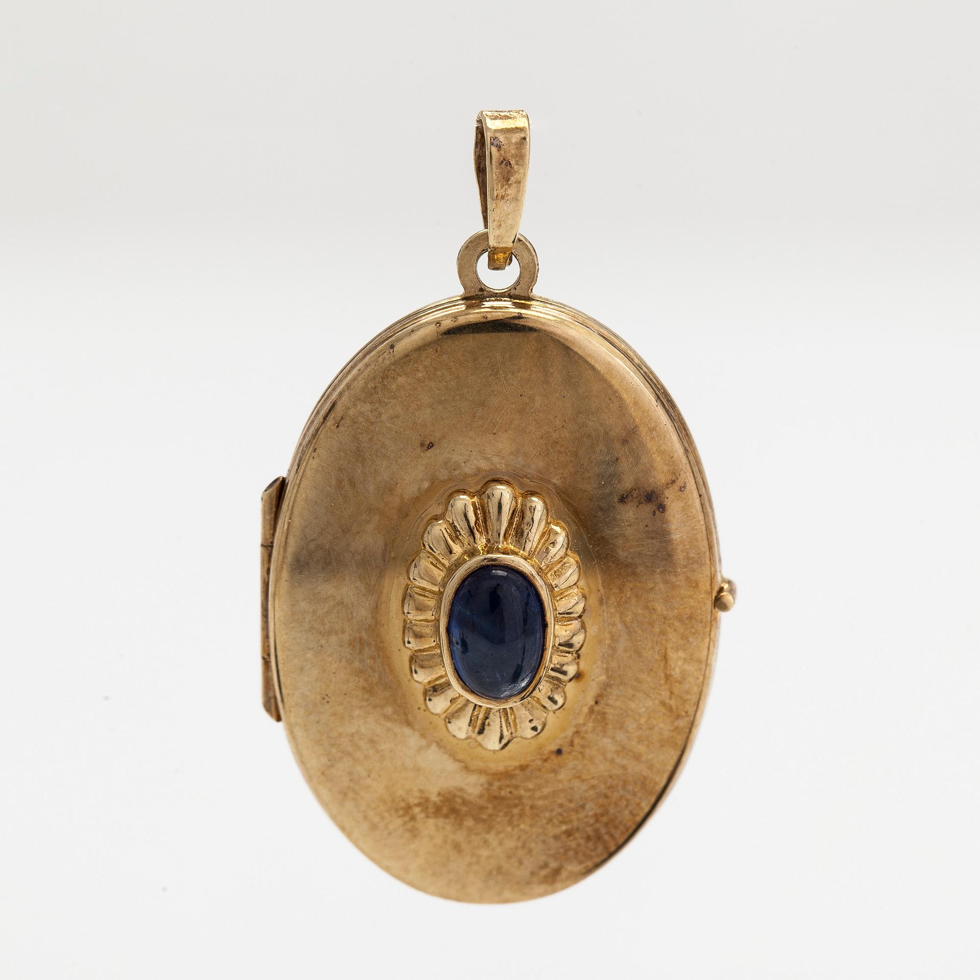Medaljonki, 14K kultaa ja cabochon-hiottu safiiri. Suomalaiset tuontileimat.