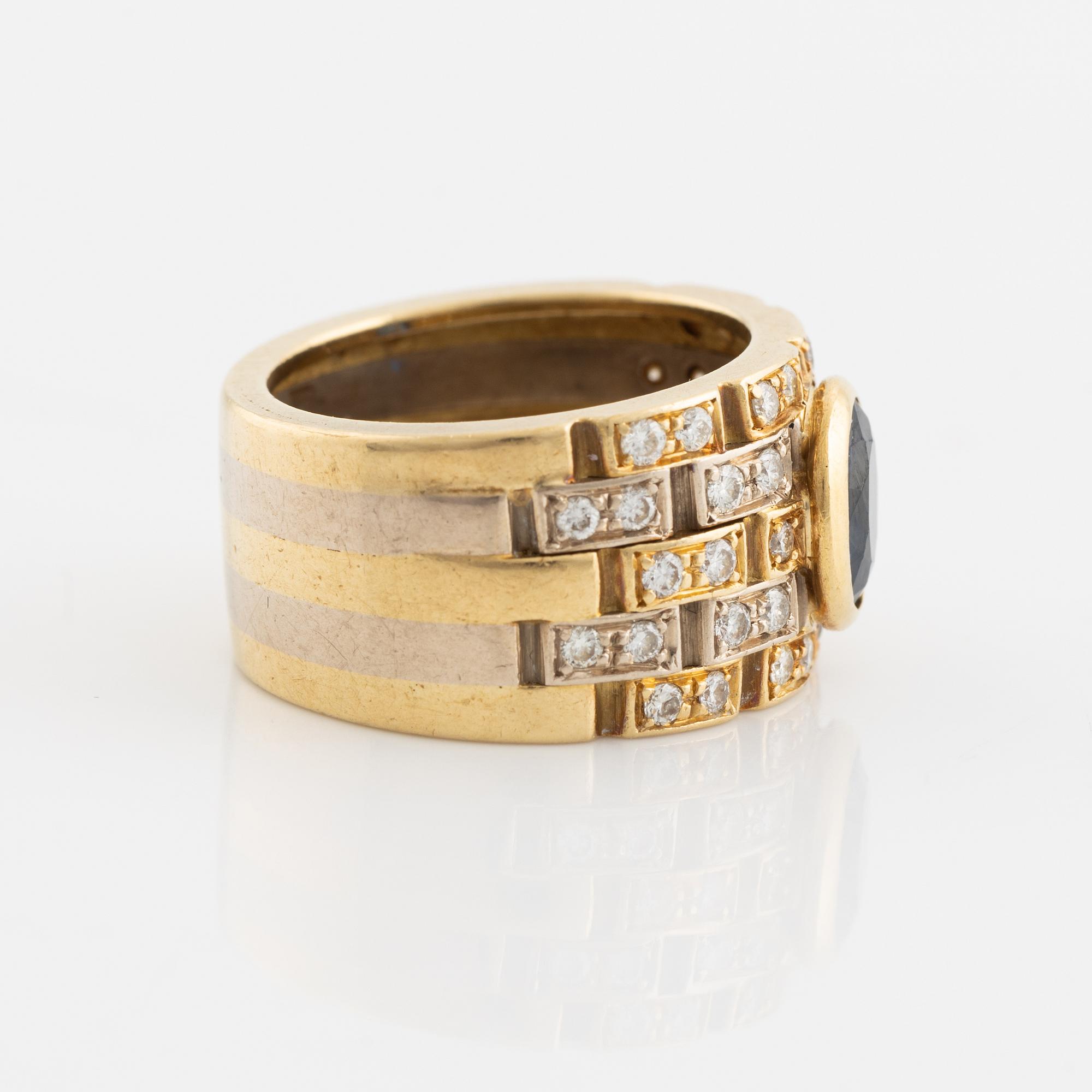 Ring 18K guld med en fasettslipad safir och runda briljantslipade diamanter.