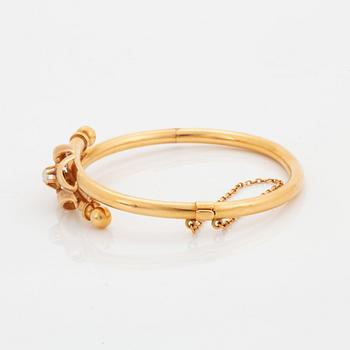 An 18K gold bangle set with a pearl.