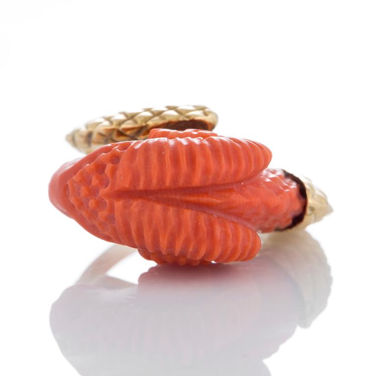 A ring in carved coral in the form of a ram's head.