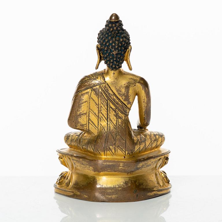 A gilt copper-alloy figure of Aksobhya Buddha, 14th/15th century, Tibet or Nepal.