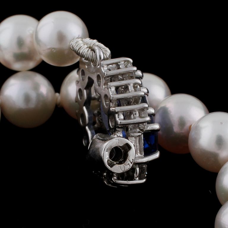 A cultured pearl necklace with a sapphire and diamond clasp.