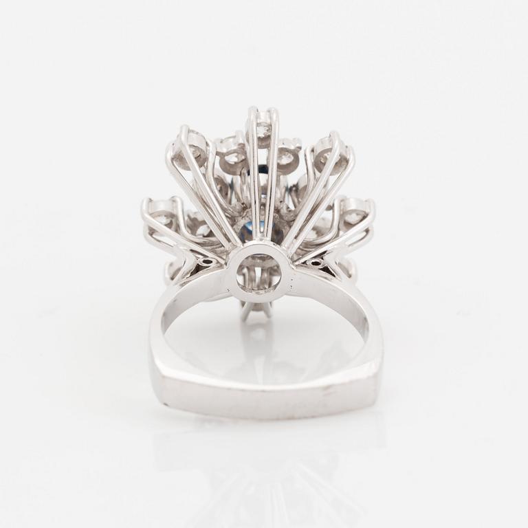 An 18K white gold ring set with a faceted sapphire and old-cut diamonds.