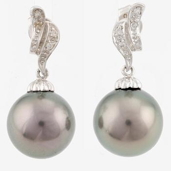 A pair of 18K gold earrings with cultured Tahitian pearls and white stones.