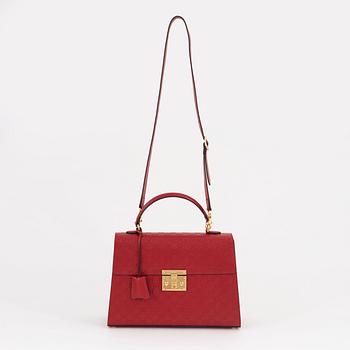 Gucci, a red, embossed leather handbag.