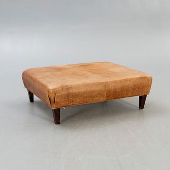 A leather ottoman/coffee table alter part of the 20th century.