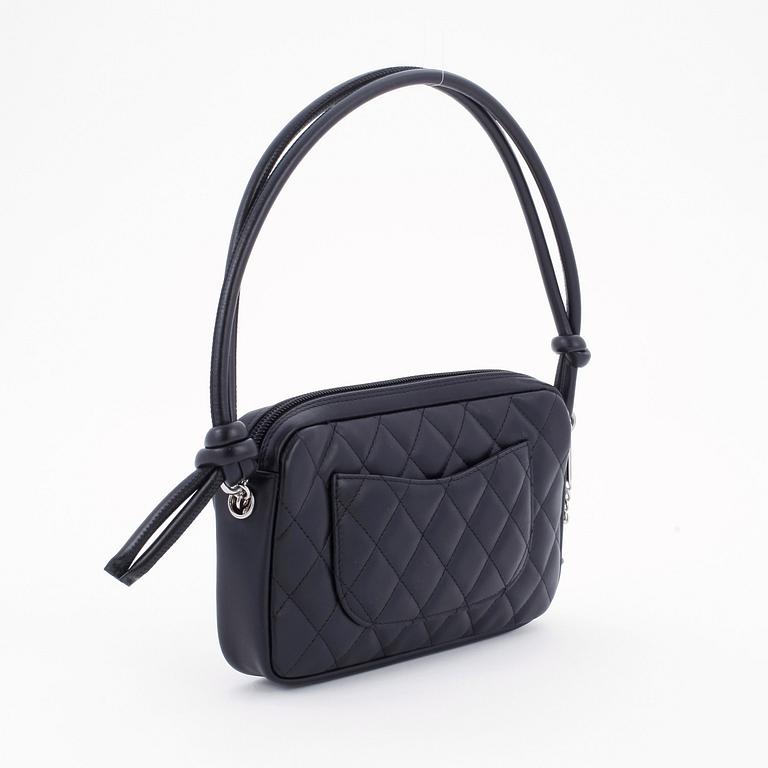 CHANEL, a black leather quilted pochette with short shoulder strap.