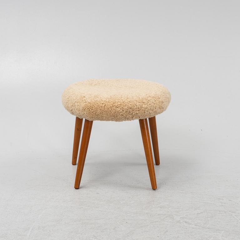 A stool with stained beech wood legs and new sheepskin upholstery, second part of the 20th Century.