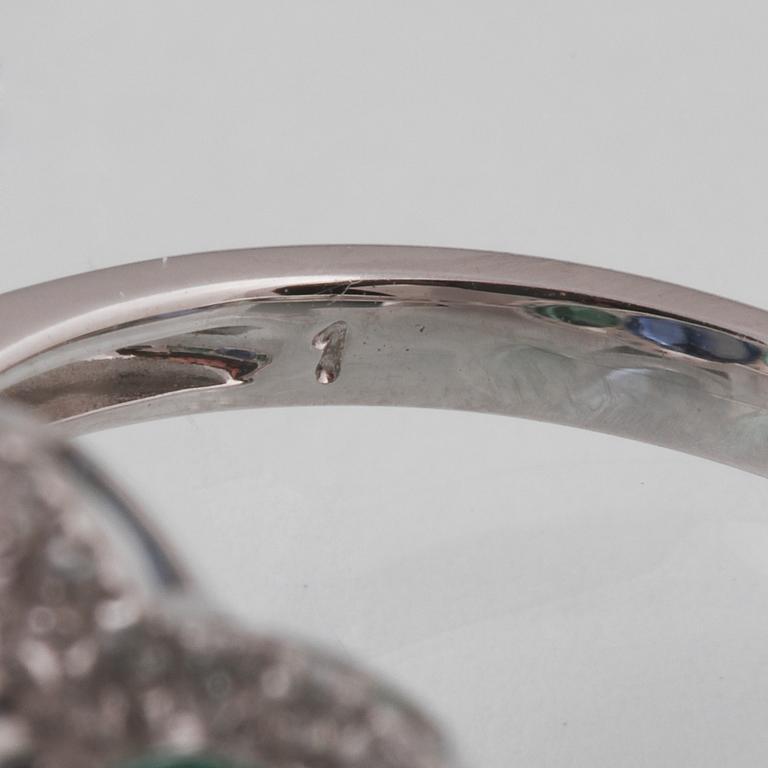 RING, 18K vitguld med fasettslipad kyanit 3.49 ct, 2 smaragder 1.23 ct och briljantslipade diamanter 0.33 ct. Vikt 3 g.
