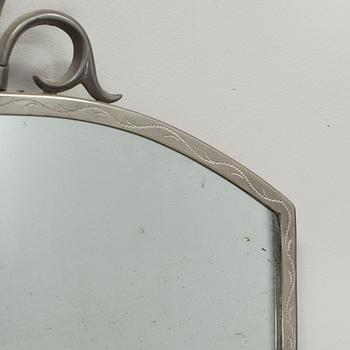 A pewter mirror and a pair of wall sconces from the first half of the 20th century.