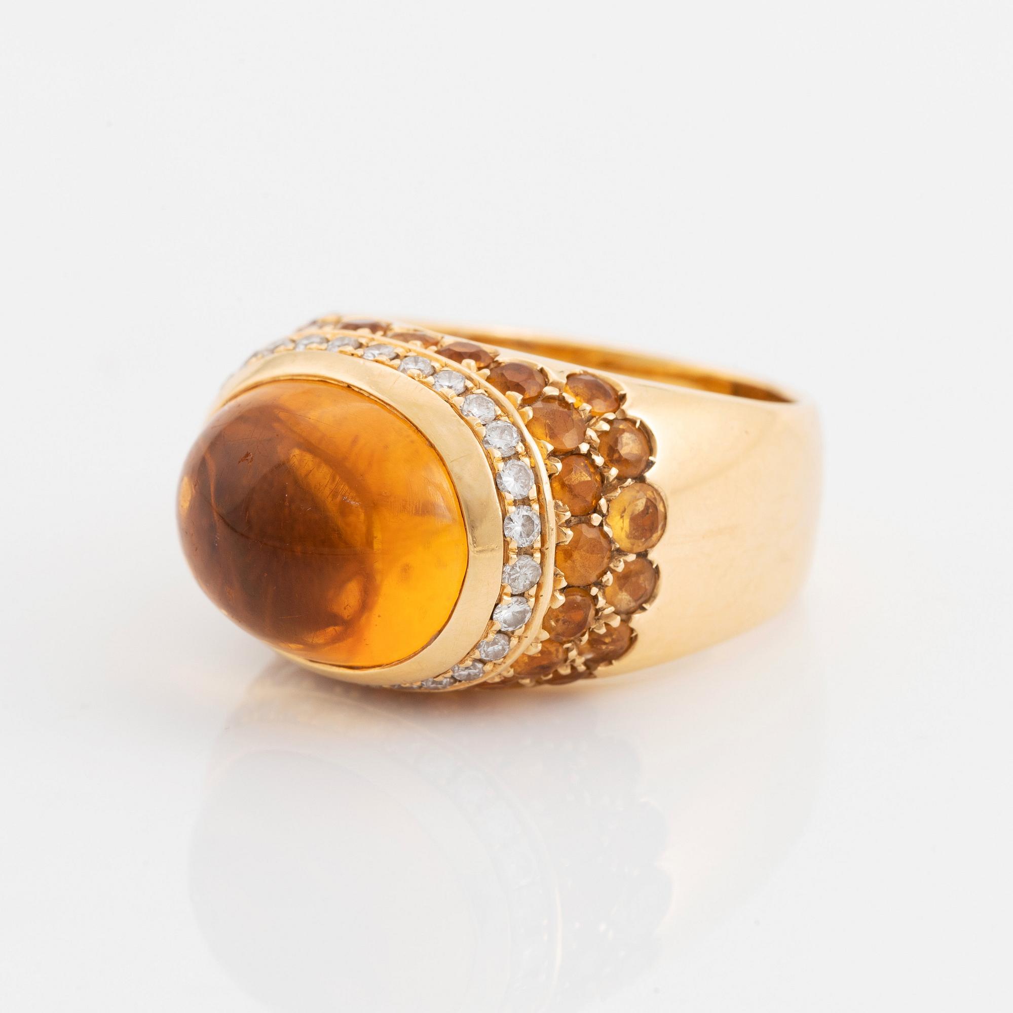 An 18K gold ring set with a cabochon-cut citrine and round brilliant-cut diamonds och citrines.