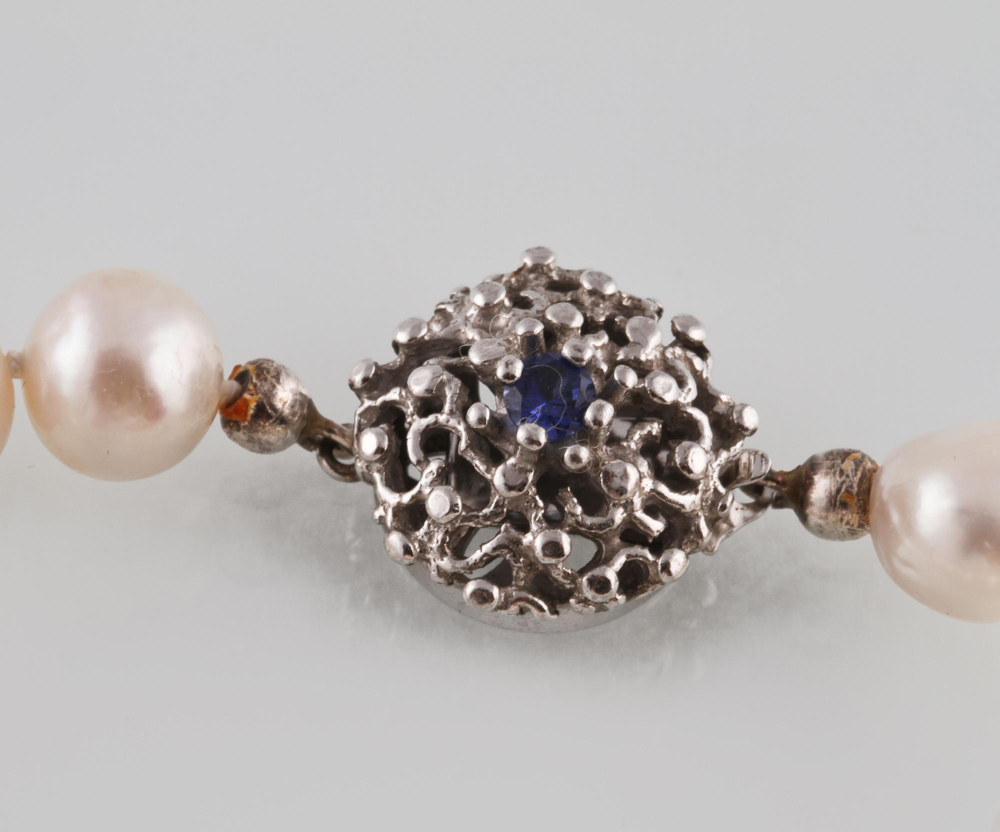 COLLIER. odlade pärlor med lås i silver med fasettslipad blå safir, utländsk stämpel. Vikt 40,5 gram.