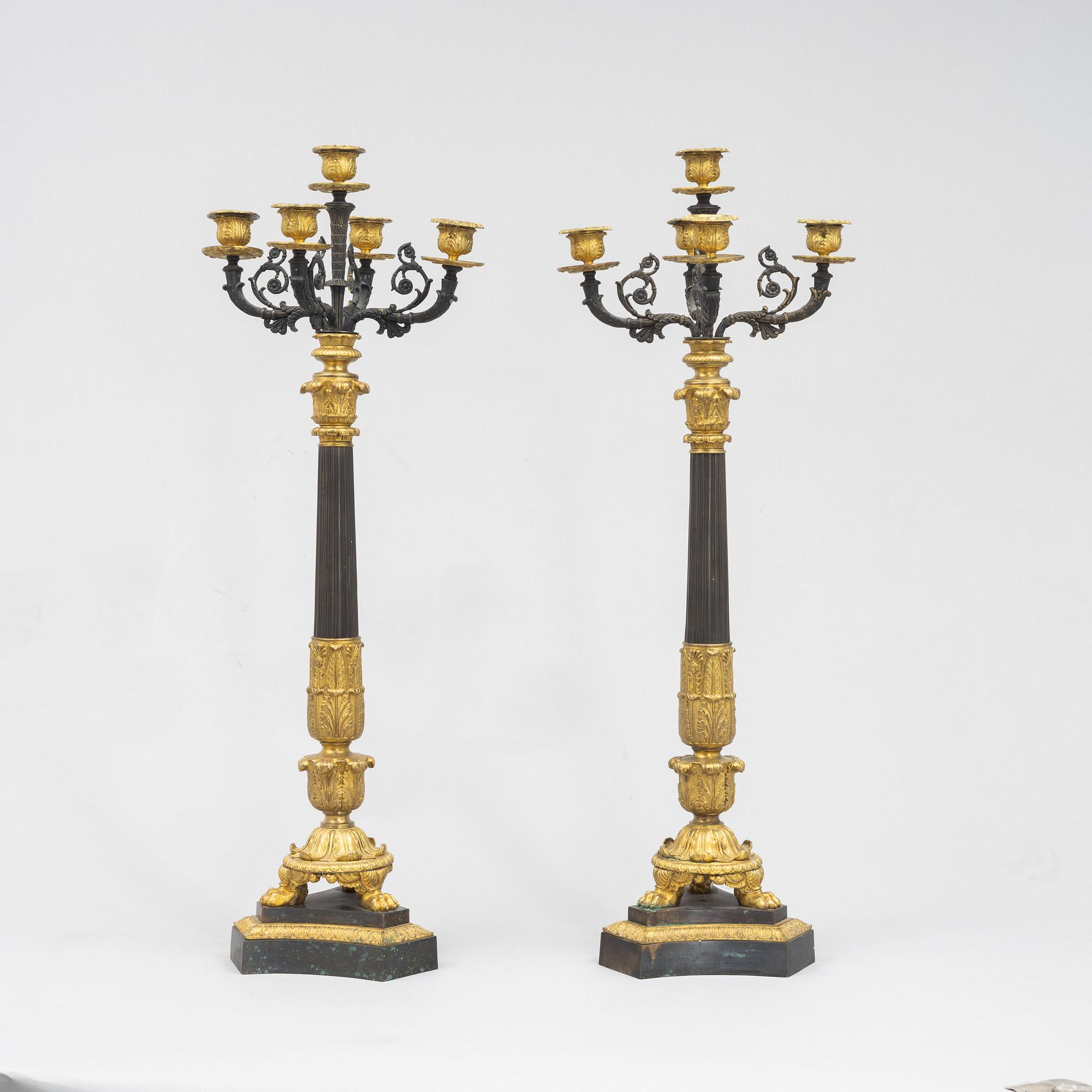 A pair of French Empire-style patinated and gilt bronze five-light candelabra, later part 19th century.