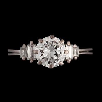 A ring with a brilliant-cut diamond flanked by baguette-cut diamonds. Total carat weights circa 1.80 cts.