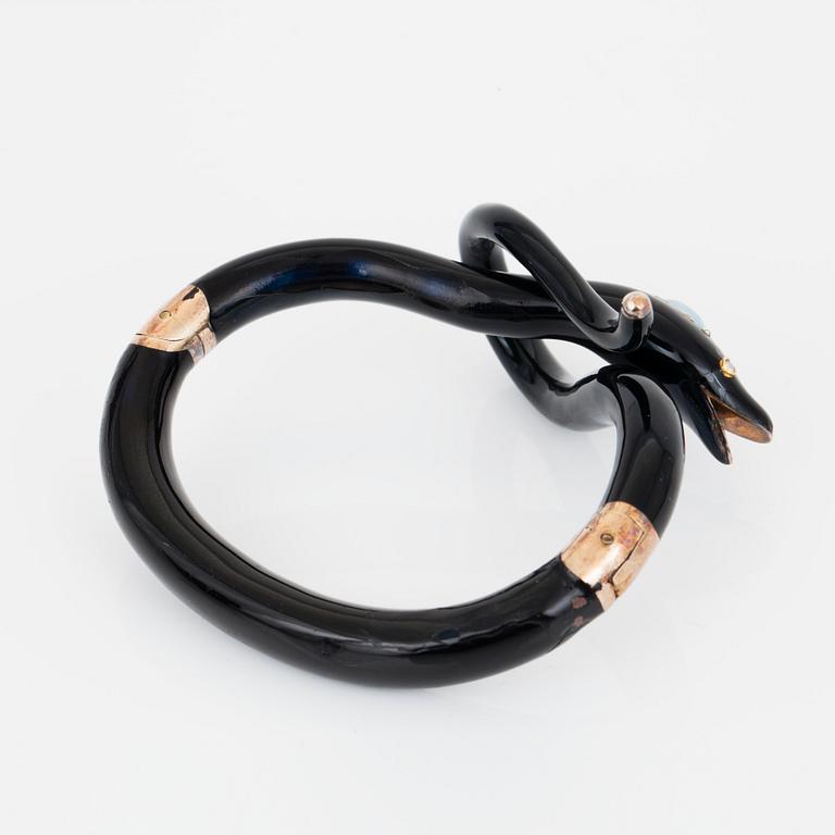 A Victorian snake bracelet in black enamel set with an opal and rose-cut diamonds.