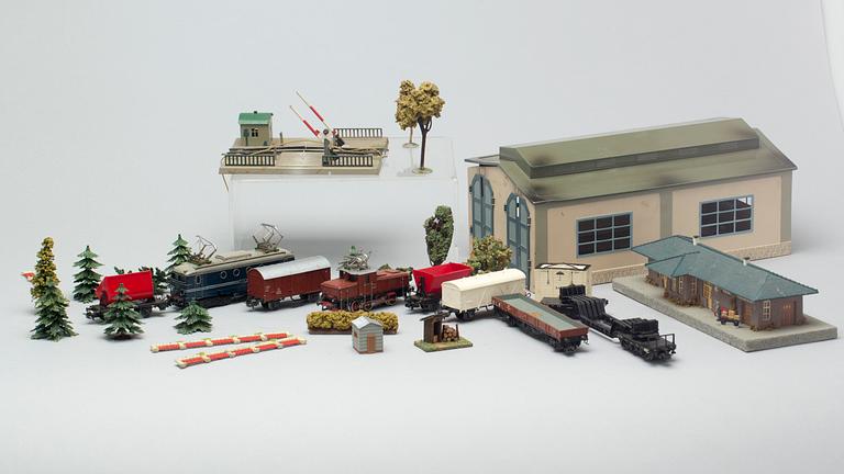 PARTI MÄRKLIN-LEKSAKER, bl a 2 ellok, vagnar, räls, byggnader, lokstall, träd, kopplingsdelar.