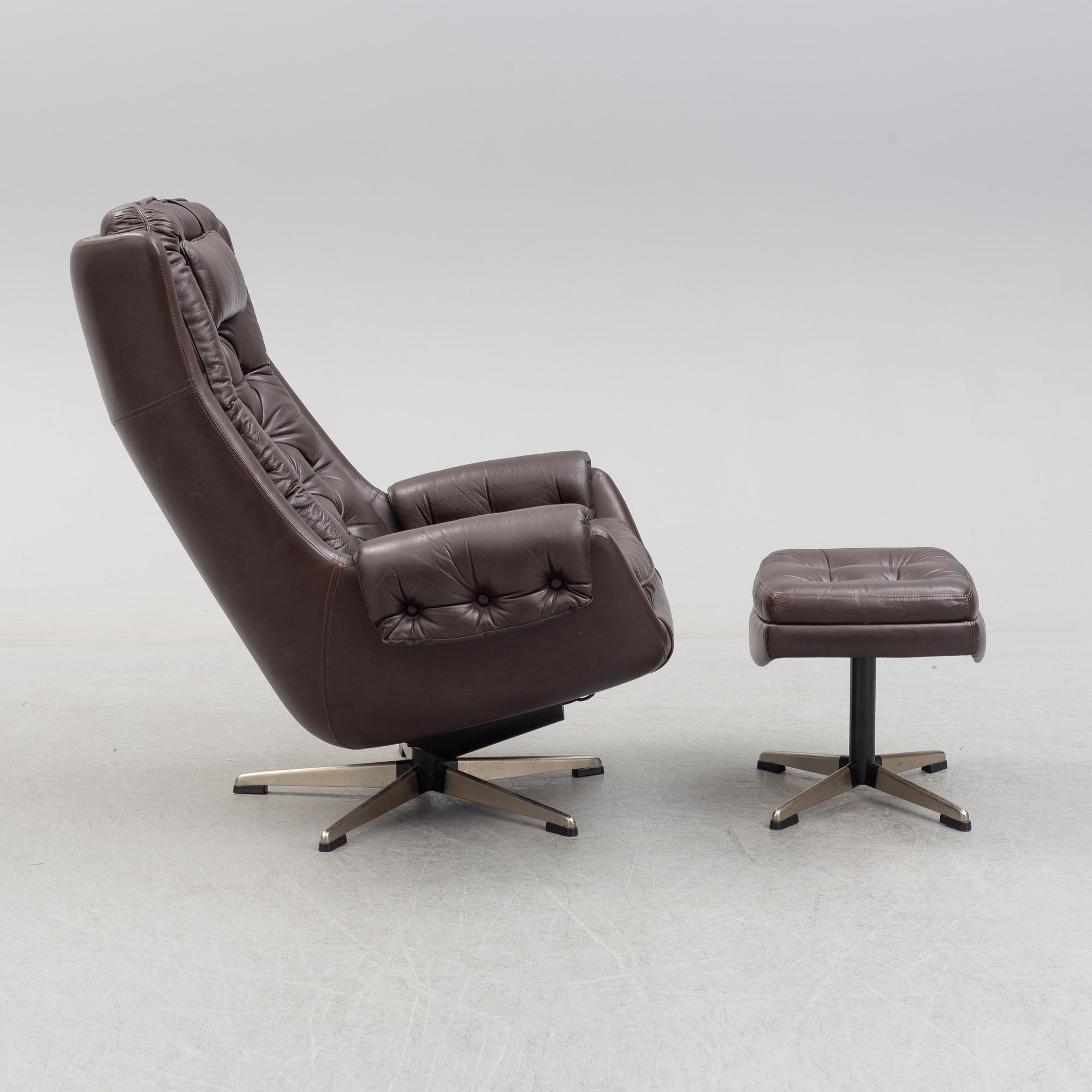 A leather upholstered easy chair with foot stool, 1960's/70's.