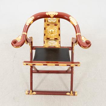 A laqcuered wooden chair from China 21st century.