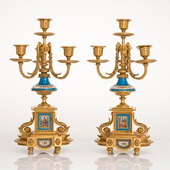 A mid-19th-century French gilt-brass mantel clock with a pair of candelabra by Dussault.