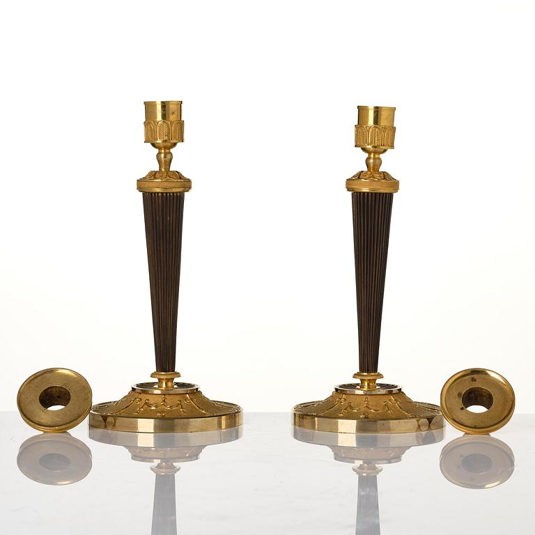 A pair of Empire ormolu and patinated bronze candlesticks.