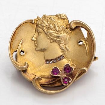 An Art Nouveau brooch, 18K gold with synthetic rubies and rose-cut diamonds.