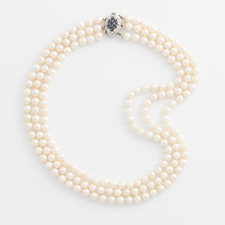 Collier, tre-radigt med odlade pärlor, lås i vitguld med safirer och små diamanter.