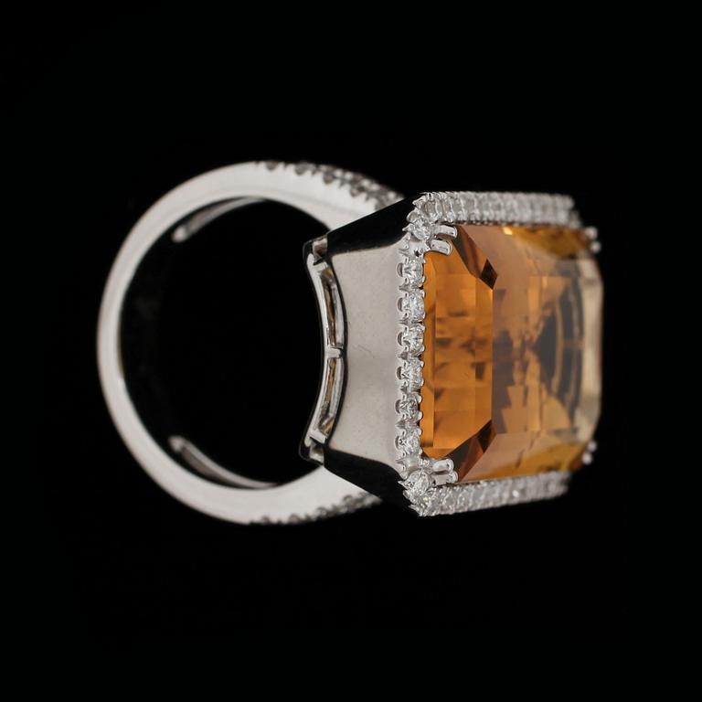 A step cut citrin ring, 25 cts, set with brilliant cut diamonds, tot 0.92 ct.