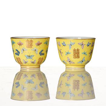 A pair of yellow glazed double happiness cups with butterflies, Qing dynasty, with Tongzhis four character mark to base.