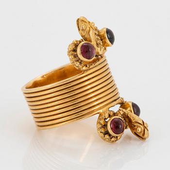 An 18K gold ring set with cabochon-cut garnets design Ilias Lalaounis.