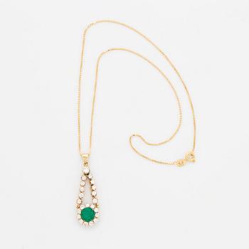 An 18K gold pendant set with a facted emerald.