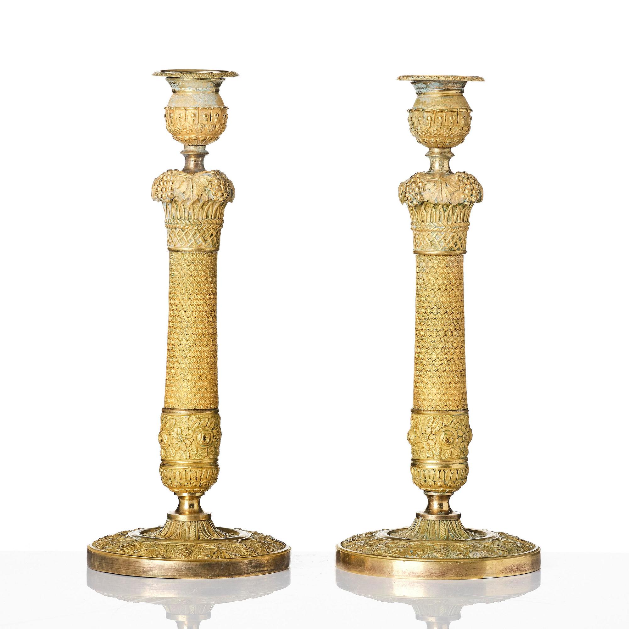 A pair of French Empire ormolu candlesticks, ca 1820's.