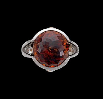 980. A faceted garnet and diamond ring, tot. app. 0.30 cts.