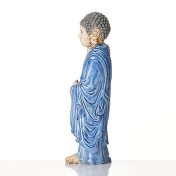 A porcelain figure of a standing Buddha, Qing dynasty, 18th Century.