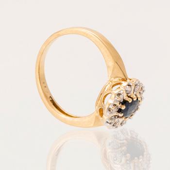 An 18K gold ring set with an oval faceted sapphire and round brilliant-cut diamonds.