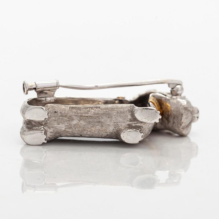 Rintaneula, 18K valkokultaa, sekä granaatteja ja briljanttihiottuja timantteja. BW&Co, Lontoo.