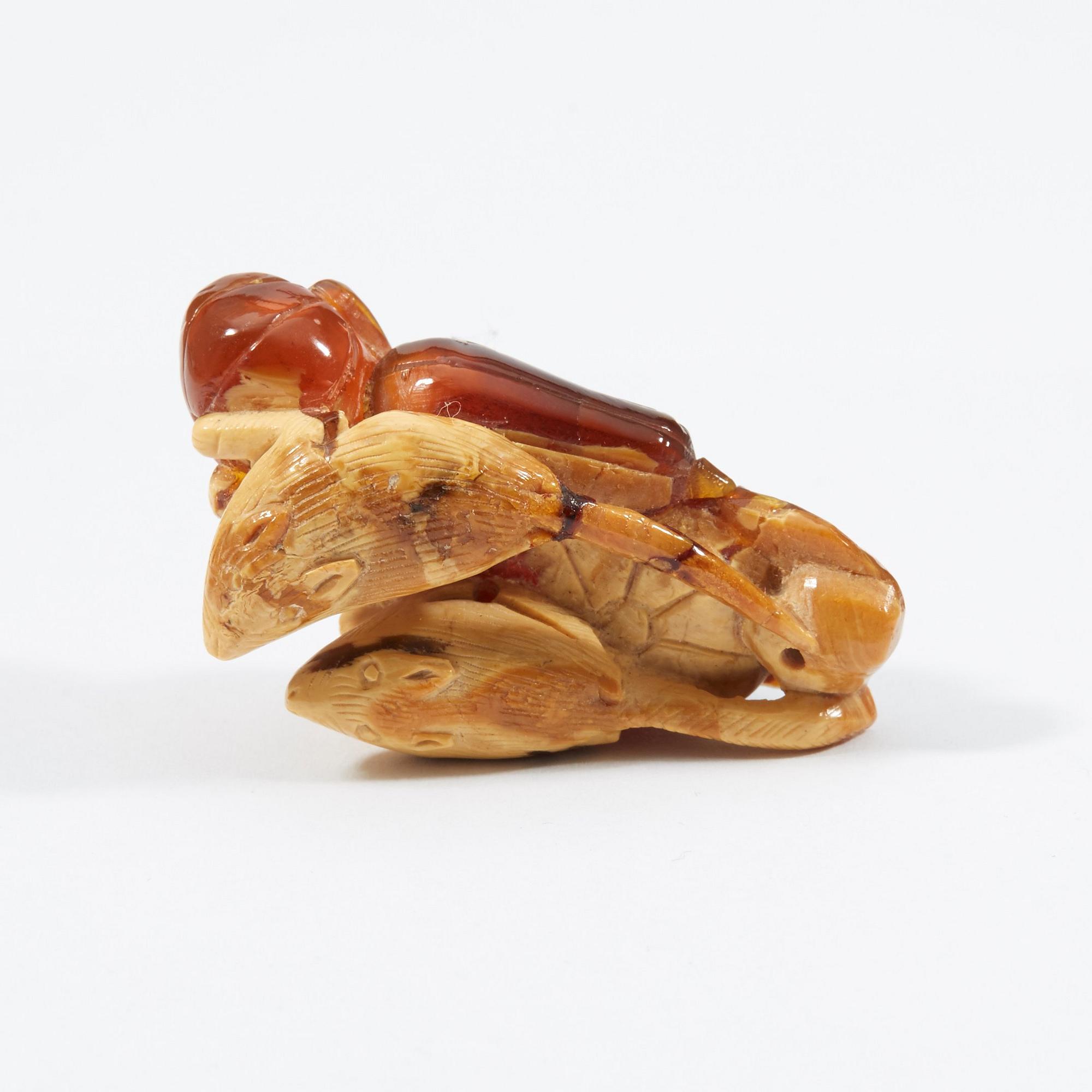 A carved amber figure/pendant of two squirrels sitting on some fruit, early 20th Century.