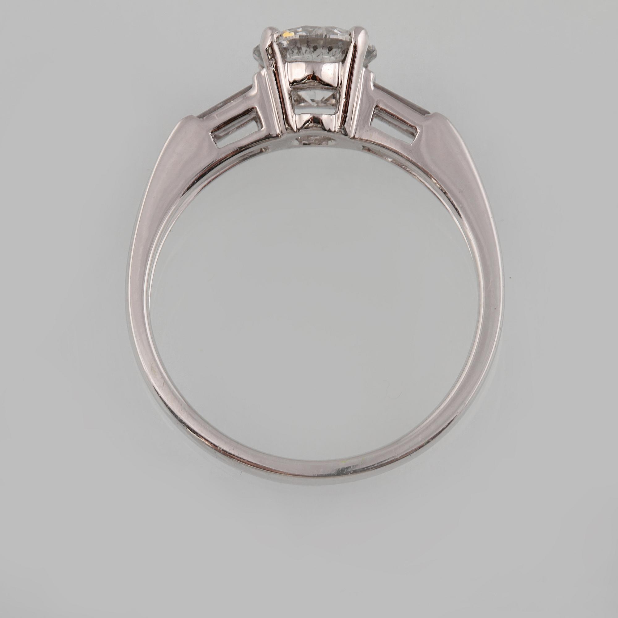 RING, 18K vitguld med briljantslipad diamant ca 1.05 ct samt 2 baguettslipade diamanter ca 0.17 ct. Vikt 3,2 gram.