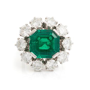 568. A WA Bolin platinum ring set with a step-cut emerald and round brilliant-cut diamonds.