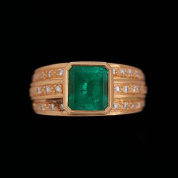 37. A step cut emerald ring set with brilliant cut diamonds.