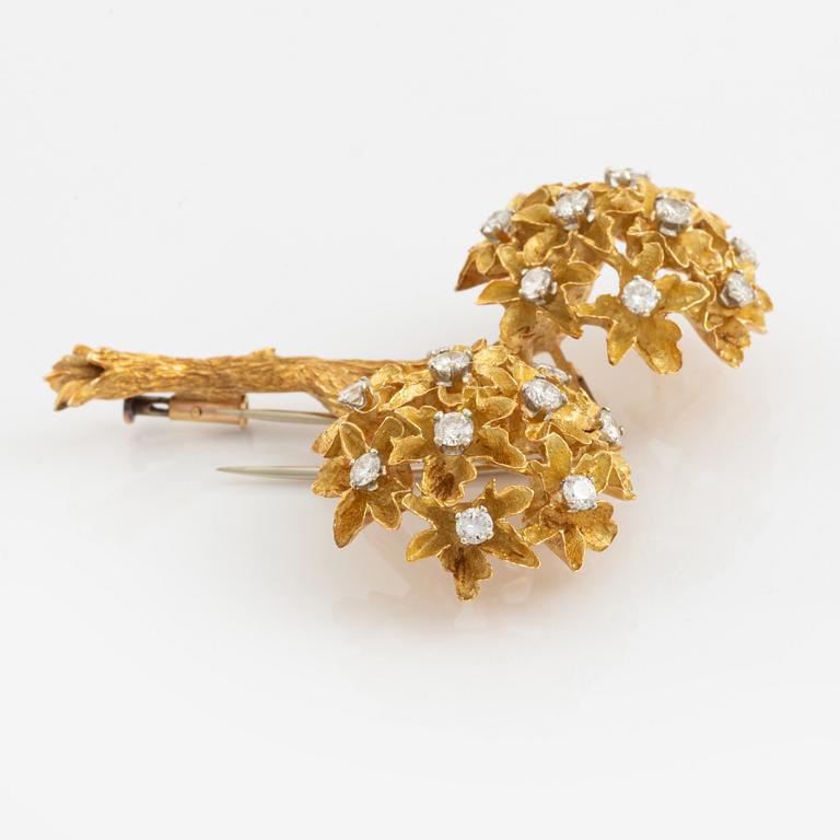 An 18K gold brooch set with round brilliant-cut diamonds.