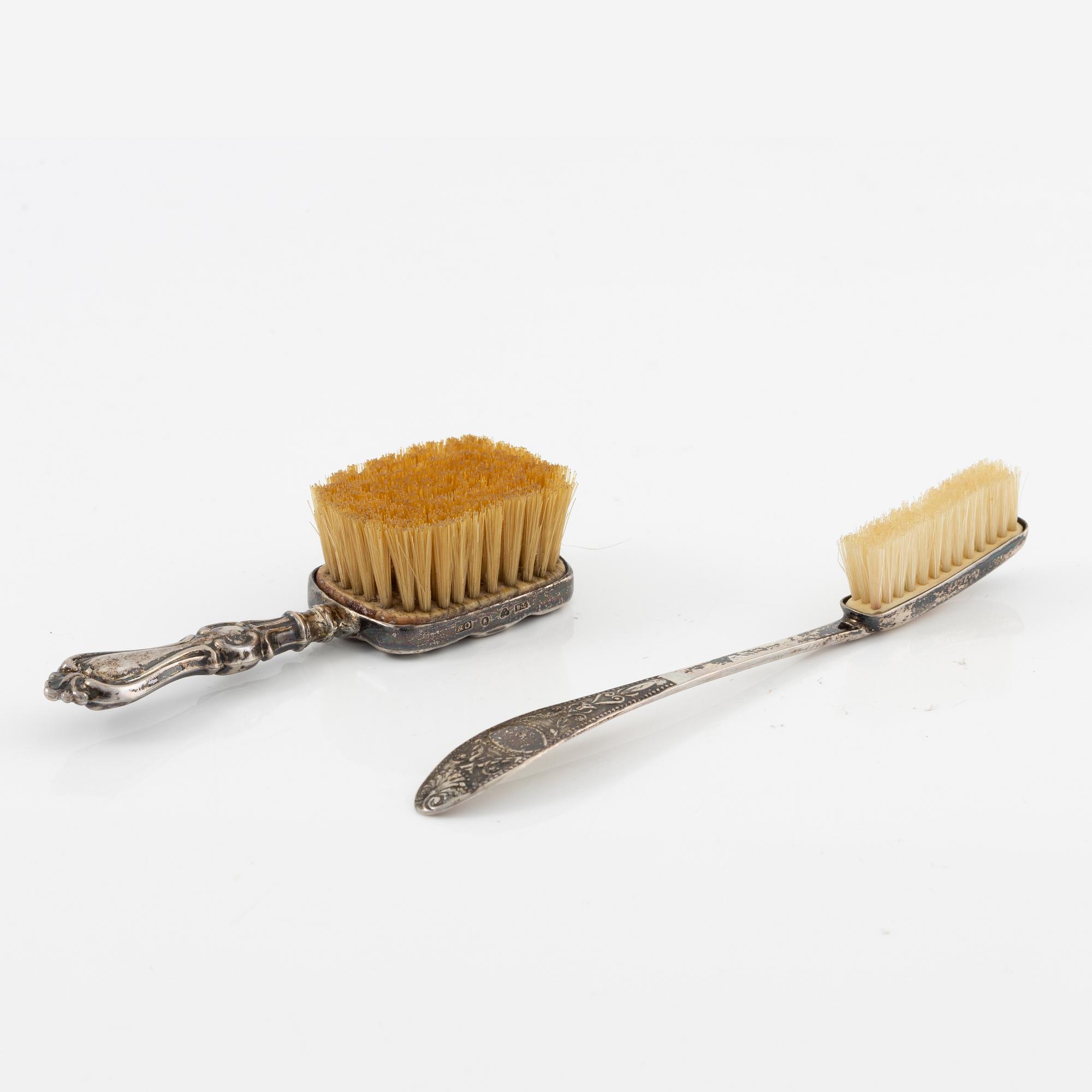 Two brushes, a hook, and a small mirror, silver and nickel silver.