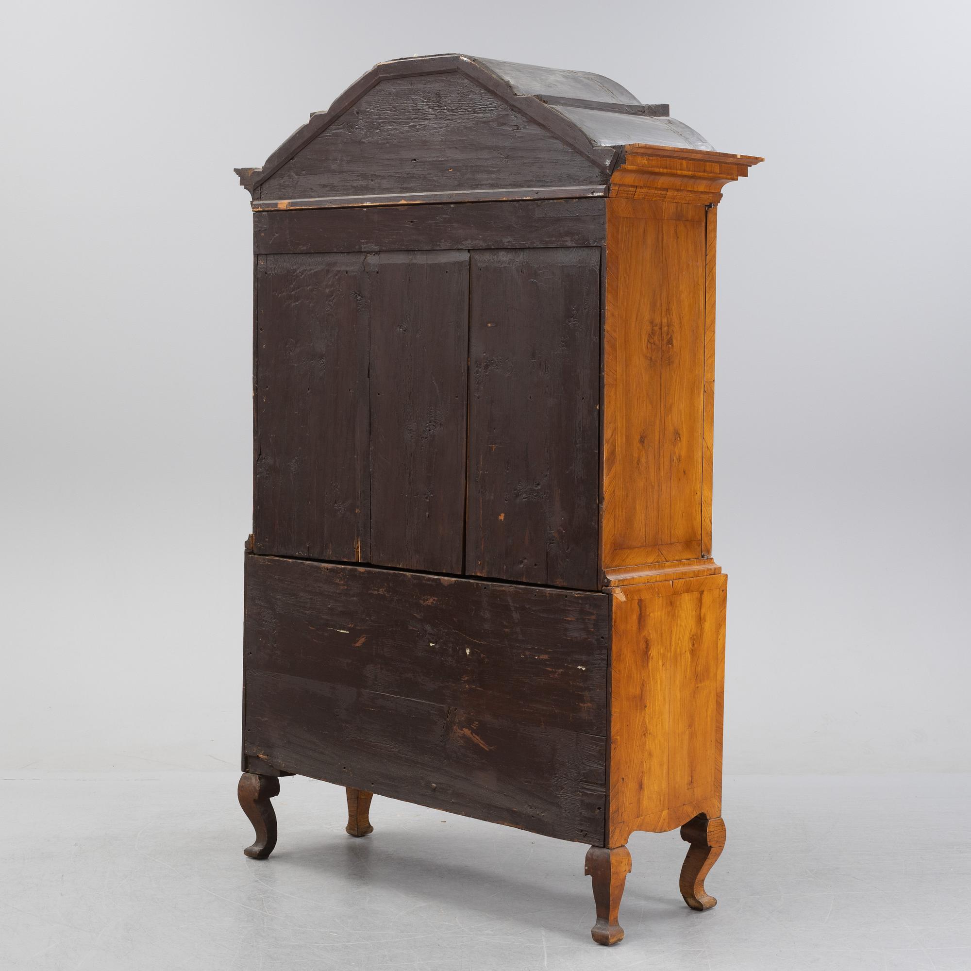 A walnut-veneered rococo cabinet in the manner of C. Linning, later part of the 18th Century.