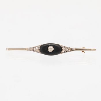 A 14K white and red gold brooch set with round brilliant-cut and rose-cut diamonds and a black stone.
