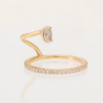 An 18K gold ring set with an oval cut and round brilliant cut diamonds by LWL Jewelry.